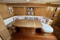 Luxurious wooden interior of 2006 Custom Felci 71 yacht with cozy seating and dining area.