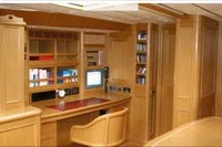 Luxurious wooden interior of a 2006 Custom Felci 71 yacht with desk and shelves.