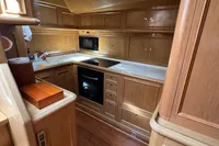 Luxurious wooden kitchen interior of 2006 Custom Felci 71 yacht, featuring modern appliances.
