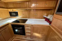 Luxurious wooden yacht kitchen with modern appliances, featuring a sleek design.