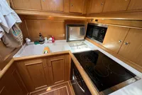 Luxurious wooden kitchen interior of 2006 Custom Felci 71 yacht with modern appliances.