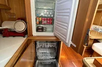Compact kitchen in 2006 Custom Felci 71 yacht with fridge and dishwasher.