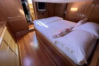 Luxurious cabin interior of 2006 Custom Felci 71 yacht with wooden finish and cozy bedding.