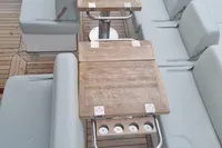 Luxurious seating and wooden table on 2019 Fjord 44 Open yacht deck.