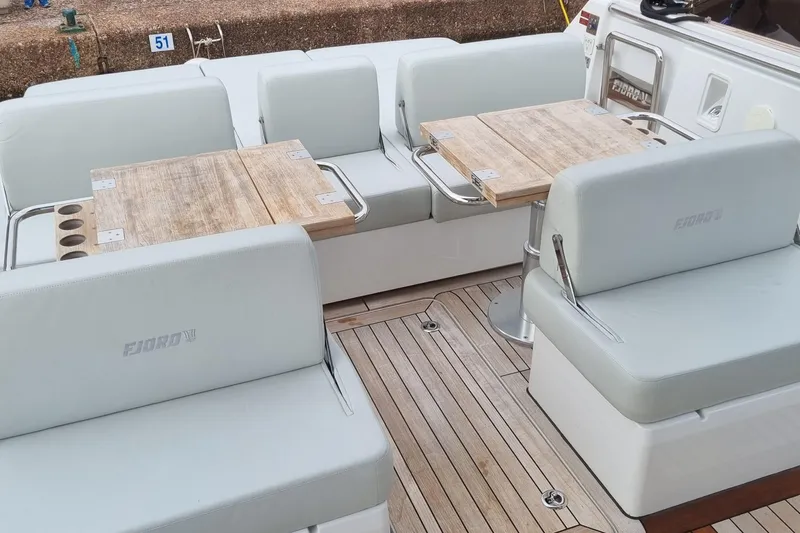  Yacht Photos Pics Luxurious seating area on a 2019 Fjord 44 Open yacht with wooden tables.