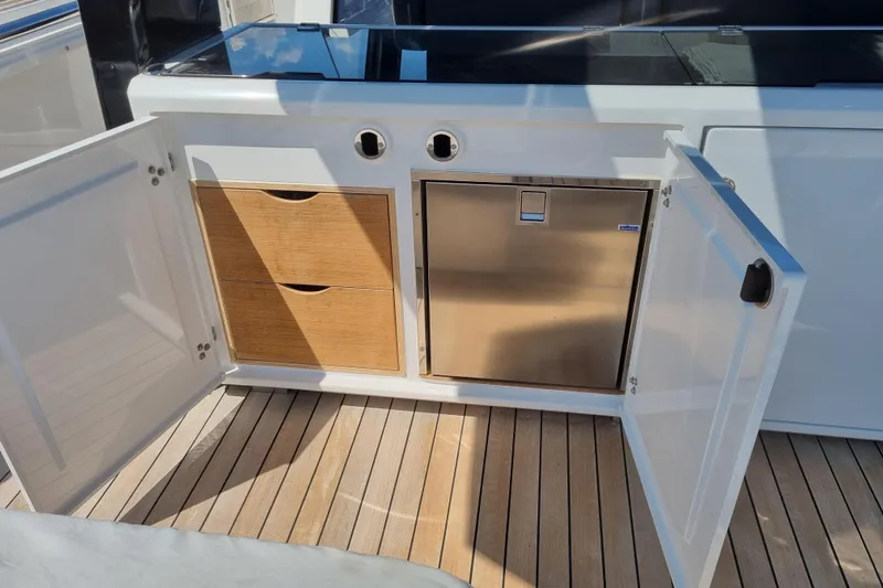  Yacht Photos Pics Open storage area on 2019 Fjord 44 Open yacht with wooden drawers and stainless steel fridge.
