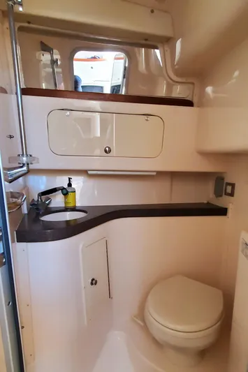 Season Pass Yacht Photos Pics 2007 Grady-White Express 330 boat bathroom with sink, toilet, and storage cabinets.