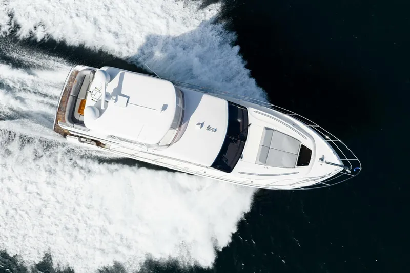 Sea Bandit Yacht Photos Pics Aerial view of 2015 Princess 56 Flybridge Motor Yacht cruising on water.