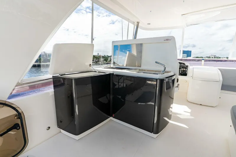 Sea Bandit Yacht Photos Pics Flybridge kitchen area on 2015 Princess 56 Motor Yacht with sleek black cabinetry.