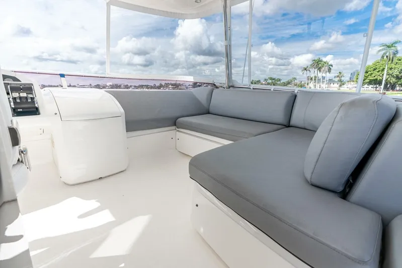 Sea Bandit Yacht Photos Pics Flybridge seating area on 2015 Princess 56 Motor Yacht, featuring gray cushions and scenic views.