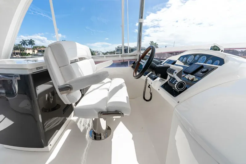 Sea Bandit Yacht Photos Pics Flybridge helm of 2015 Princess 56 Yacht with white seating and modern controls.