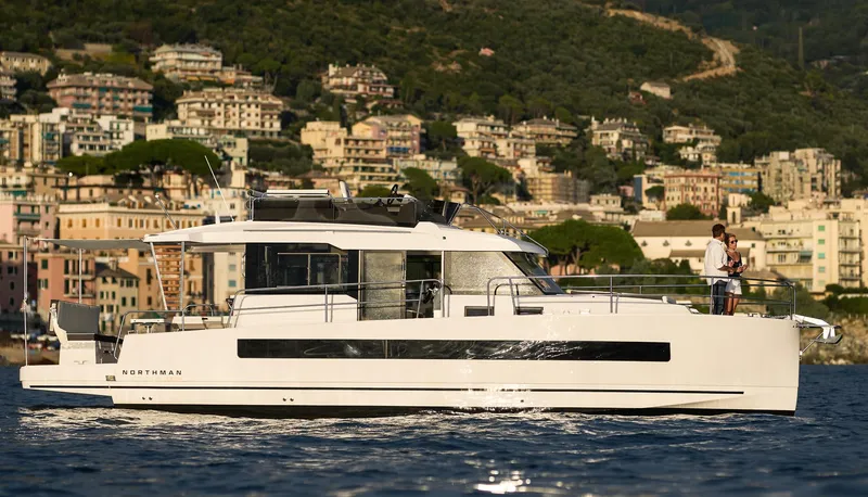  Yacht Photos Pics 2025 Northman 1300 yacht cruising near scenic coastal town.