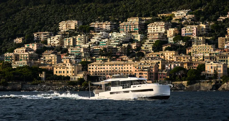  Yacht Photos Pics 2025 Northman 1300 yacht cruising near a scenic coastal town.