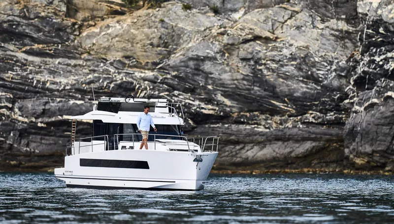  Yacht Photos Pics Man on Northman 1300 yacht near rocky shoreline, 2025 model.