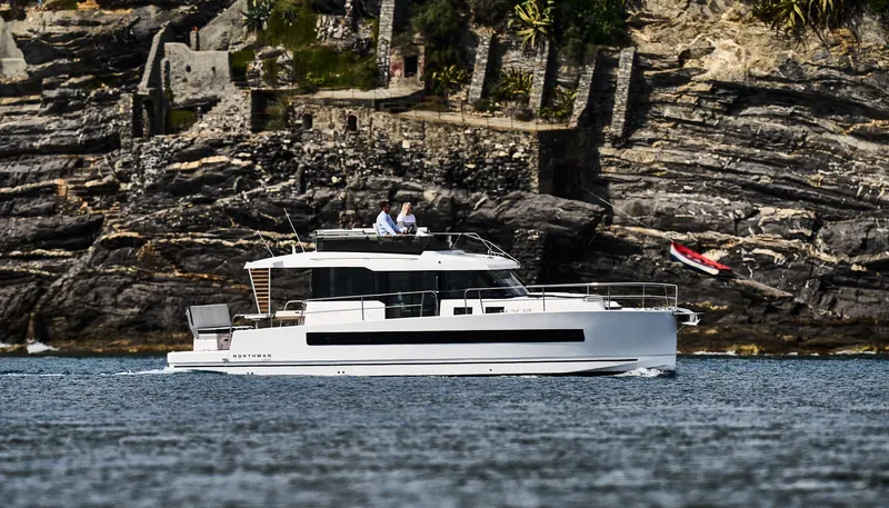  Yacht Photos Pics 2025 Northman 1300 yacht cruising near rocky shoreline.