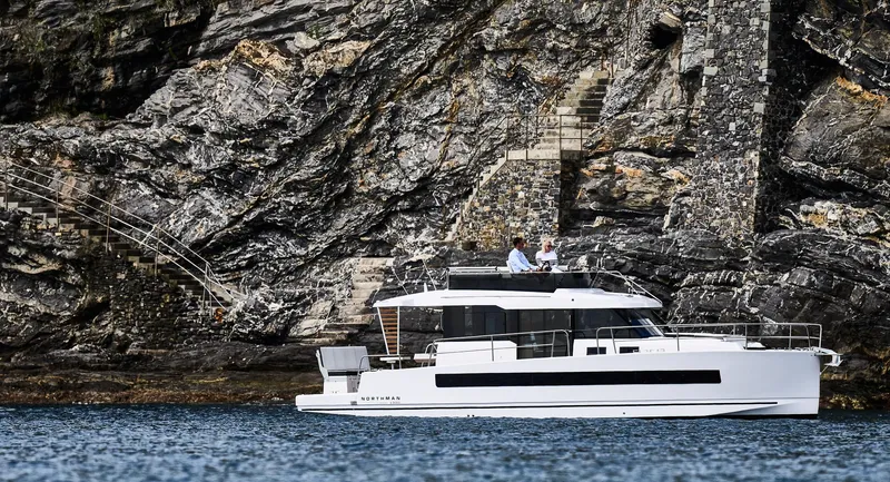  Yacht Photos Pics 2025 Northman 1300 yacht cruising near rocky cliffs.