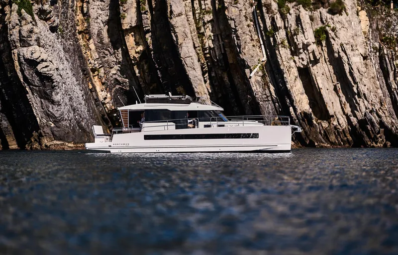  Yacht Photos Pics 2025 Northman 1300 yacht cruising near rocky cliffs.