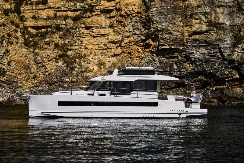  Yacht Photos Pics 2025 Northman 1300 yacht cruising near rocky cliffs.