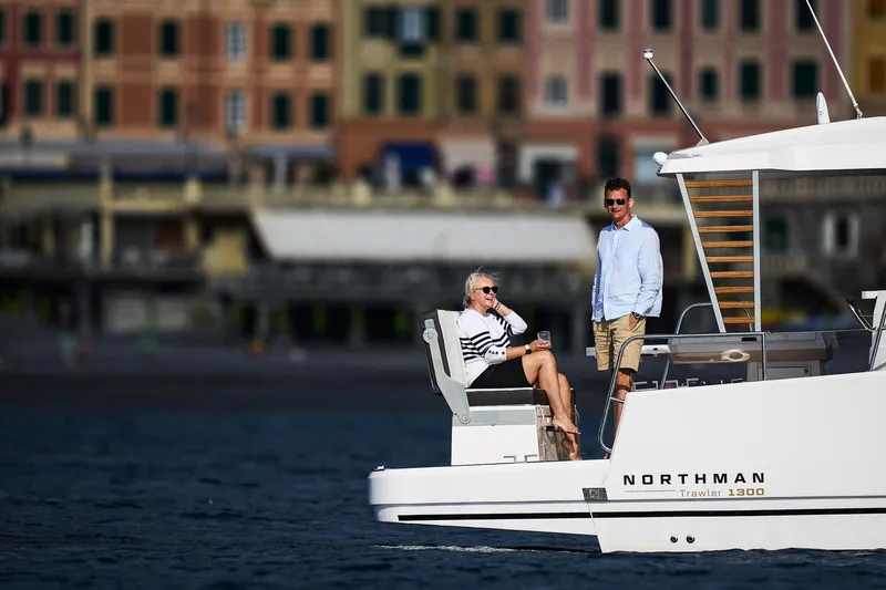  Yacht Photos Pics Couple enjoying leisure time on a 2025 Northman 1300 yacht near a coastal town.