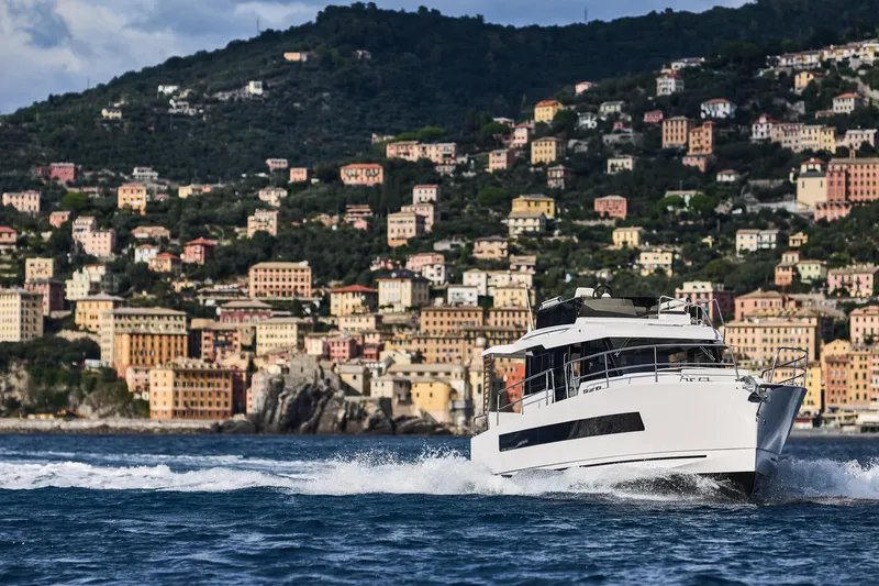  Yacht Photos Pics 2025 Northman 1300 yacht cruising near colorful coastal town.