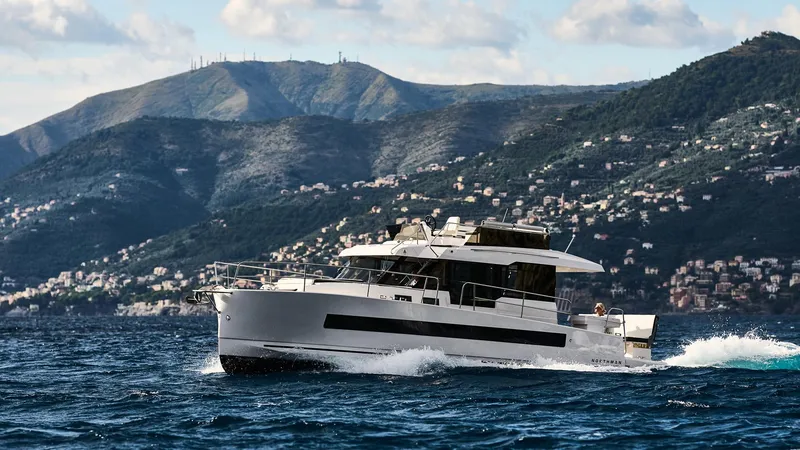  Yacht Photos Pics 2025 Northman 1300 yacht cruising on scenic coastal waters with mountainous backdrop.