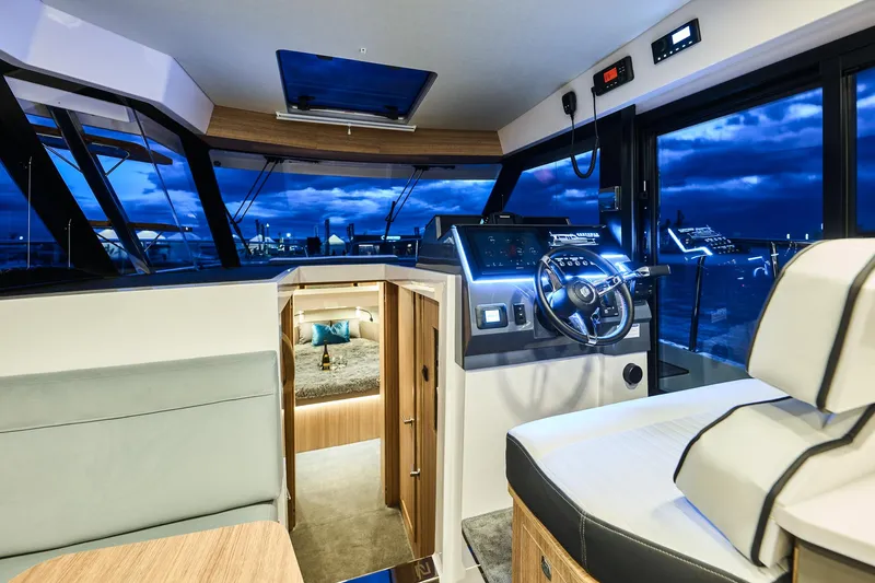  Yacht Photos Pics Luxurious interior of 2025 Northman 1300 yacht with modern helm and cozy cabin.