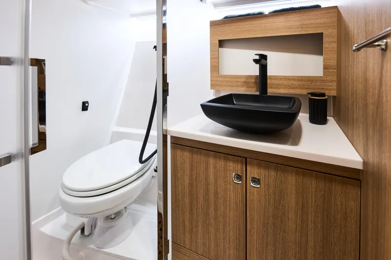  Yacht Photos Pics Modern bathroom in 2025 Northman 1300 yacht with sleek black sink and wooden cabinetry.