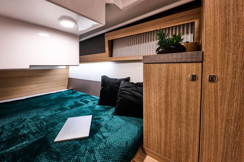  Yacht Photos Pics Interior of Northman 1300, 2026, featuring cozy bed and wooden cabinets.