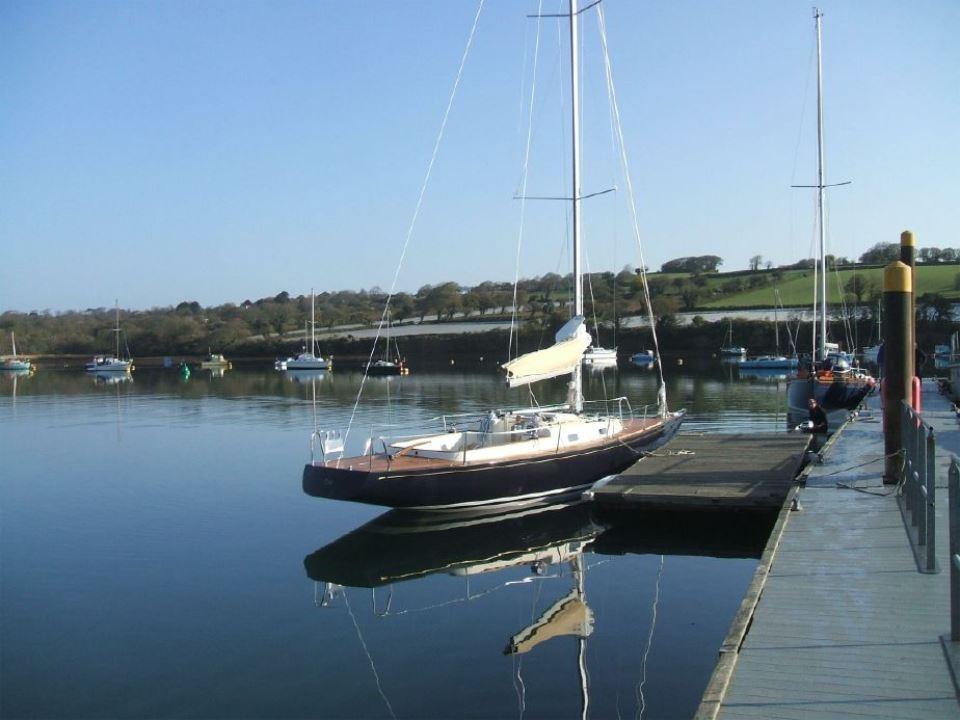 Sailboat Rustler 33, 2025 model, docked in a serene marina setting.