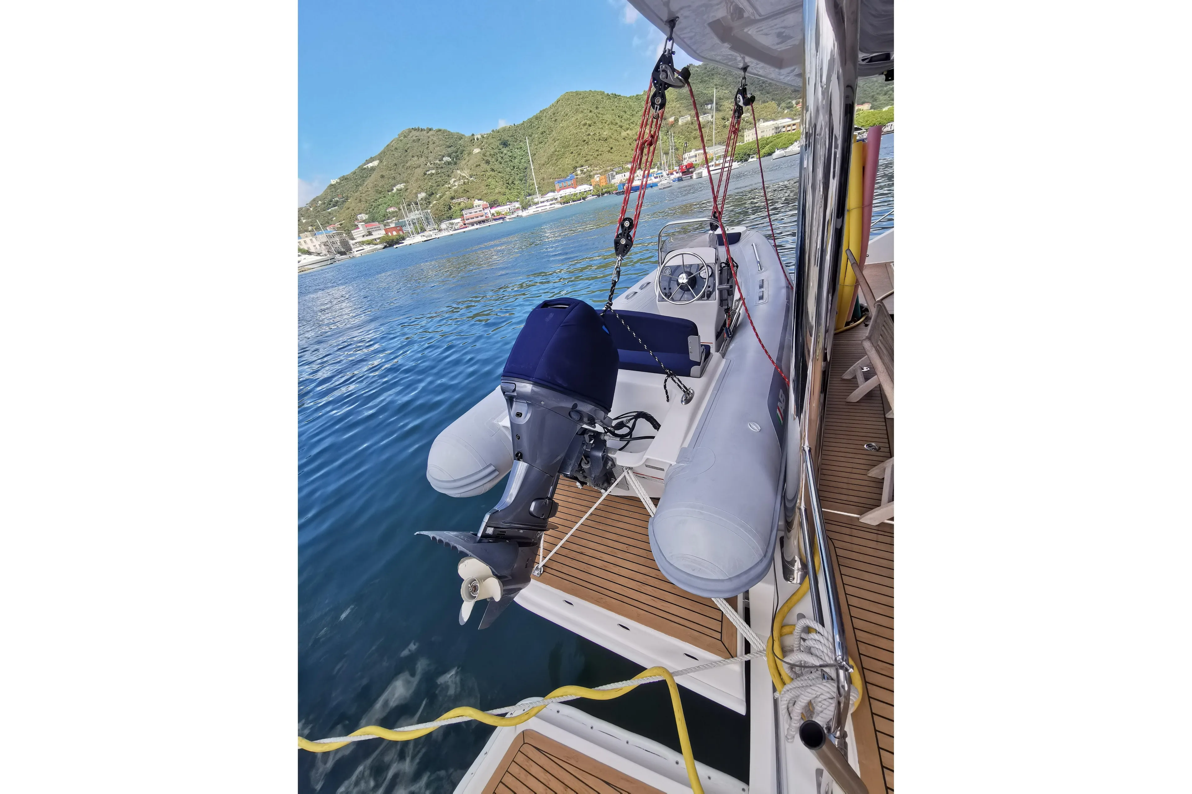 Leopard 58 yacht with dinghy, docked by scenic waterfront, 2020 model.