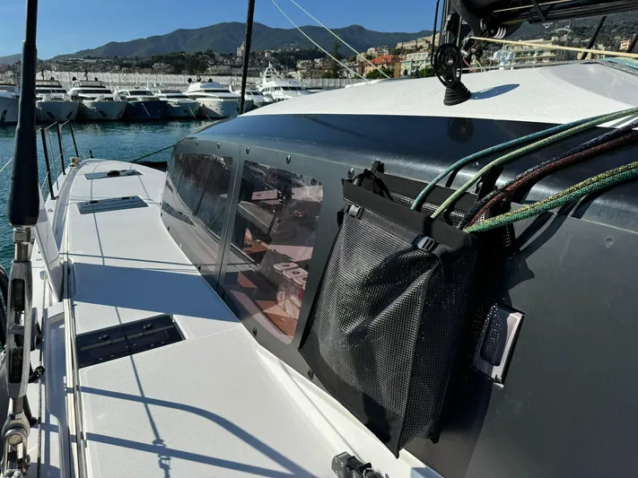  Yacht Photos Pics 2023 Outremer 55 yacht deck with ropes, docked in a marina, mountains in background.