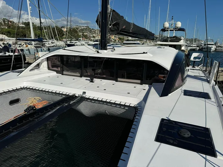  Yacht Photos Pics 2023 Outremer 55 catamaran docked at a marina, showcasing sleek design and spacious deck.