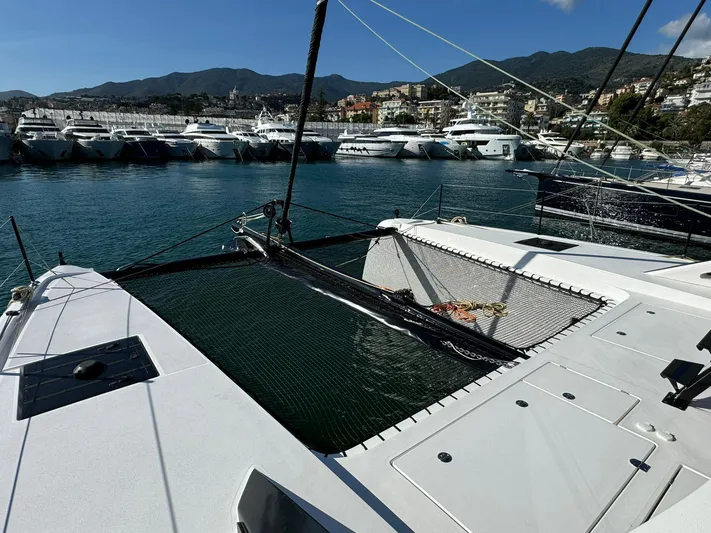  Yacht Photos Pics 2023 Outremer 55 catamaran docked in a marina with scenic mountain backdrop.