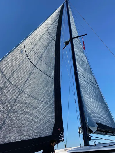  Yacht Photos Pics 2023 Outremer 55 sailboat with large sails against a clear blue sky.