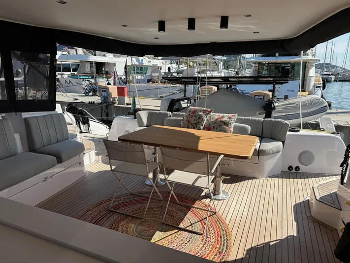  Yacht Photos Pics 2023 Outremer 55 yacht interior with seating, table, and marina view.