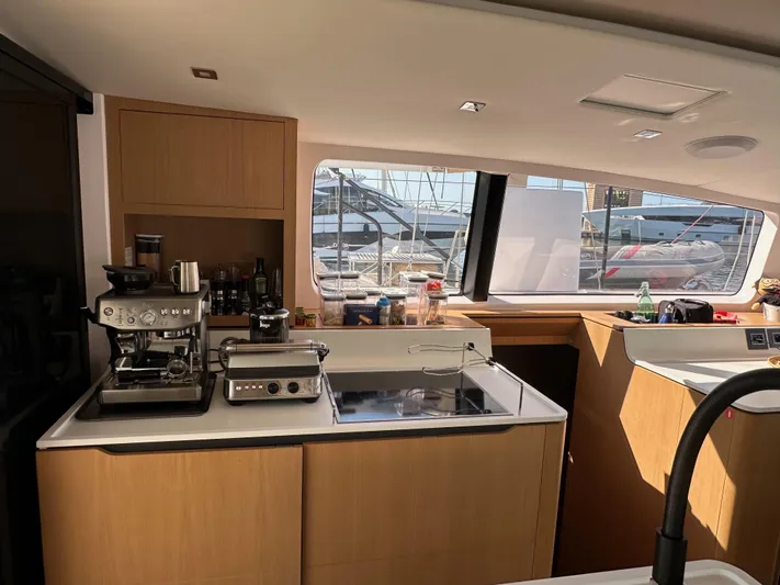  Yacht Photos Pics Modern kitchen interior of 2023 Outremer 55 yacht with appliances and window view.