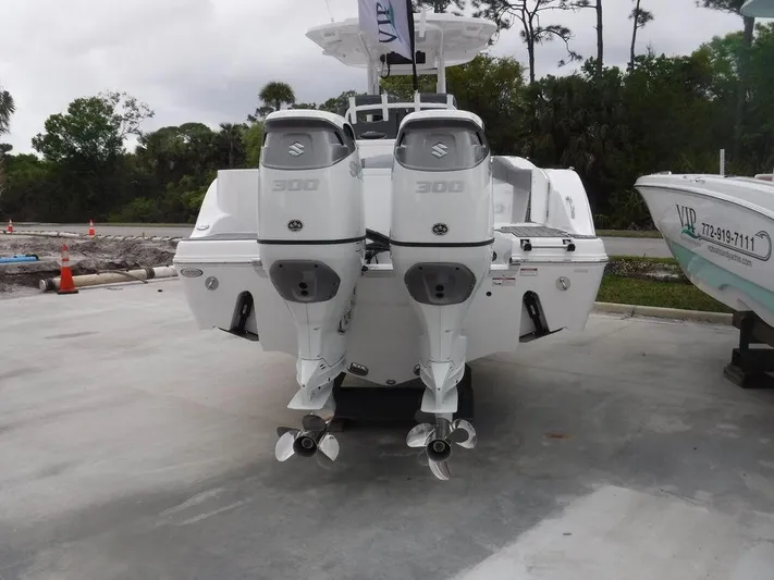  Yacht Photos Pics 2025 NauticStar 292 Legacy boat with dual Suzuki 300 outboard engines, parked on concrete.