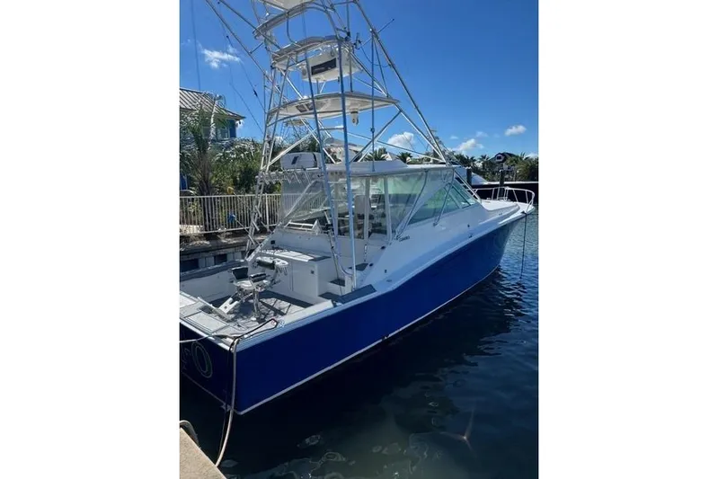 Foam O Yacht Photos Pics 2000 Cabo 45 Express boat docked in sunny marina, featuring blue hull and tower.