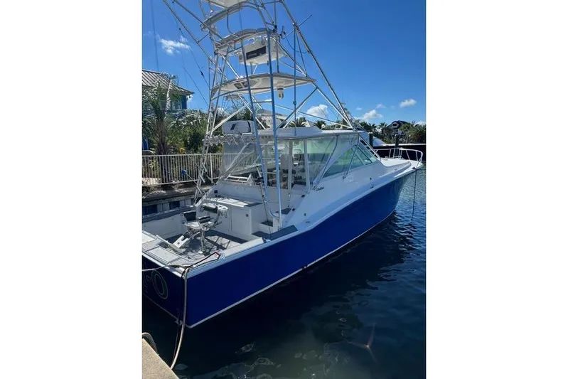 Foam O Yacht Photos Pics 2000 Cabo 45 Express boat docked, featuring a blue hull and tower under clear skies.