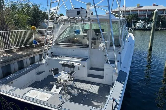 Foam O Yacht Photos Pics 2000 Cabo 45 Express boat docked, featuring spacious deck and fishing equipment.