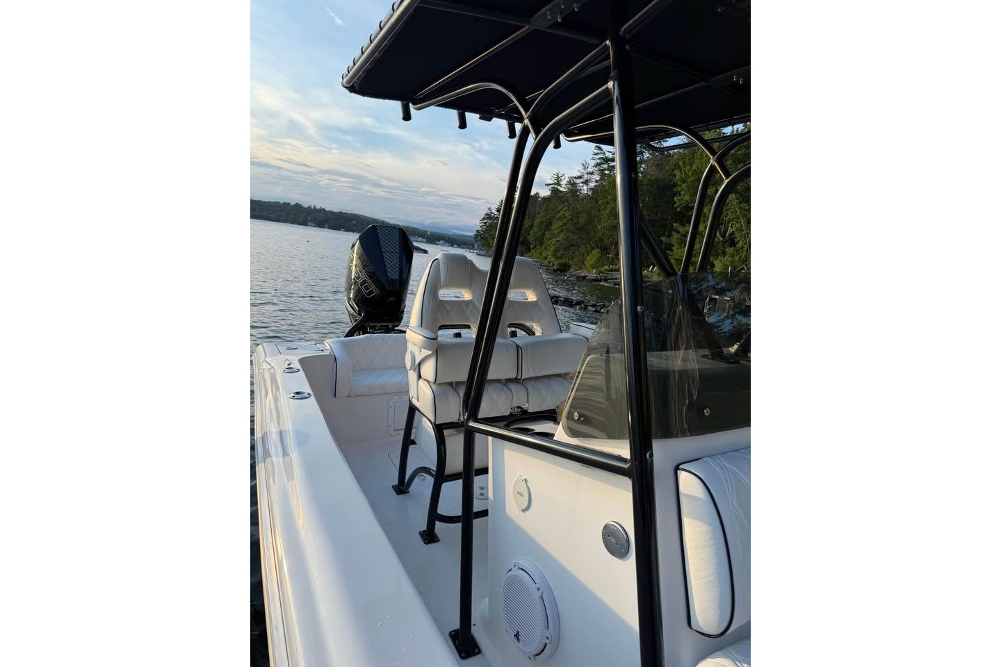 Boat interior with seating and controls, Concept 27 model, 2004, on a serene lake.
