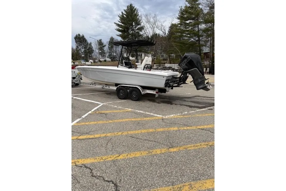 Boat on trailer in parking lot, Concept 27 model, 2004, with outboard motor.