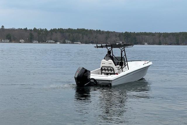 A 2004 Concept 27 boat on a calm lake with forested shoreline.