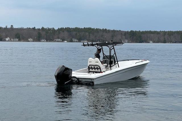 A 2004 Concept 27 boat on a calm lake with a person steering.