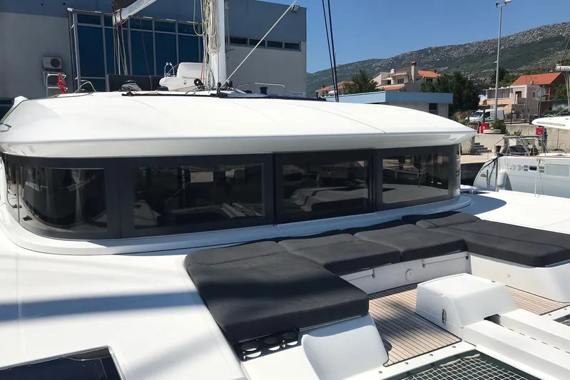  Yacht Photos Pics 2019 Lagoon 50 catamaran with sleek design and spacious deck in marina setting.