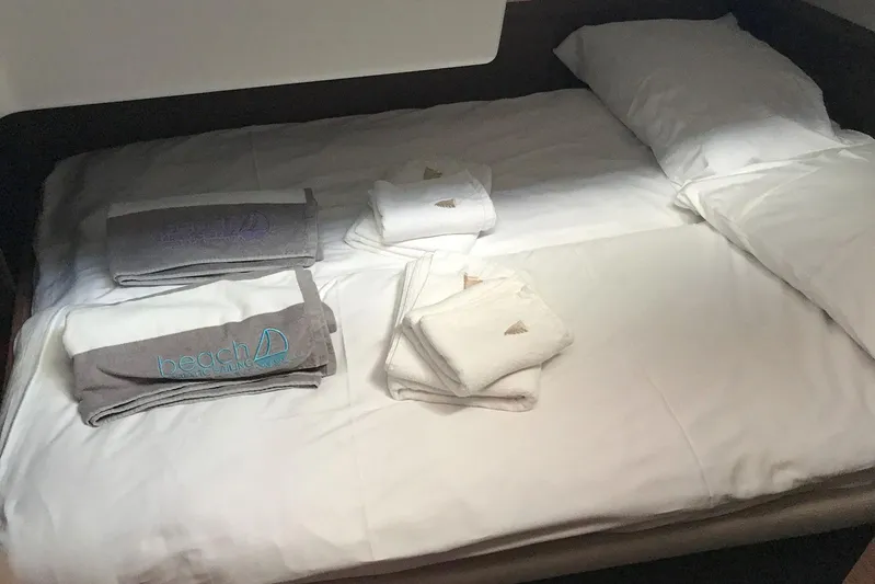  Yacht Photos Pics Cozy bed with neatly folded towels on a 2019 Lagoon 50 yacht.