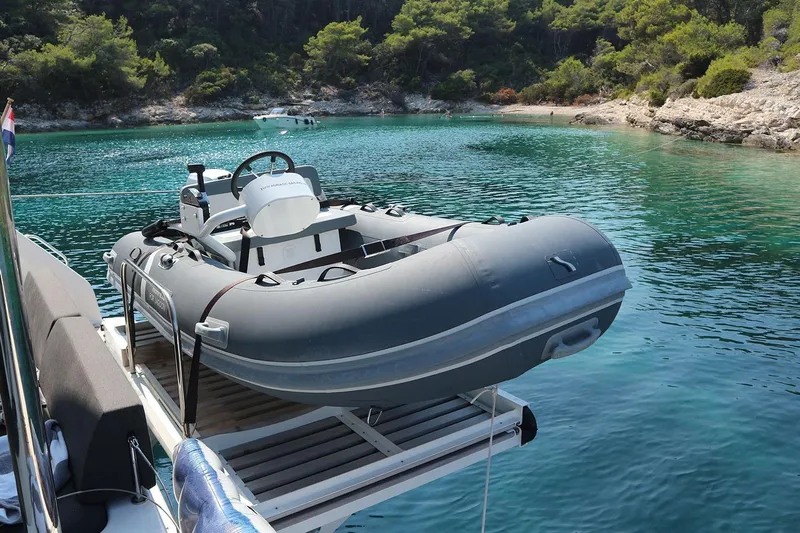  Yacht Photos Pics 2019 Lagoon 50 yacht with inflatable dinghy in a serene bay.
