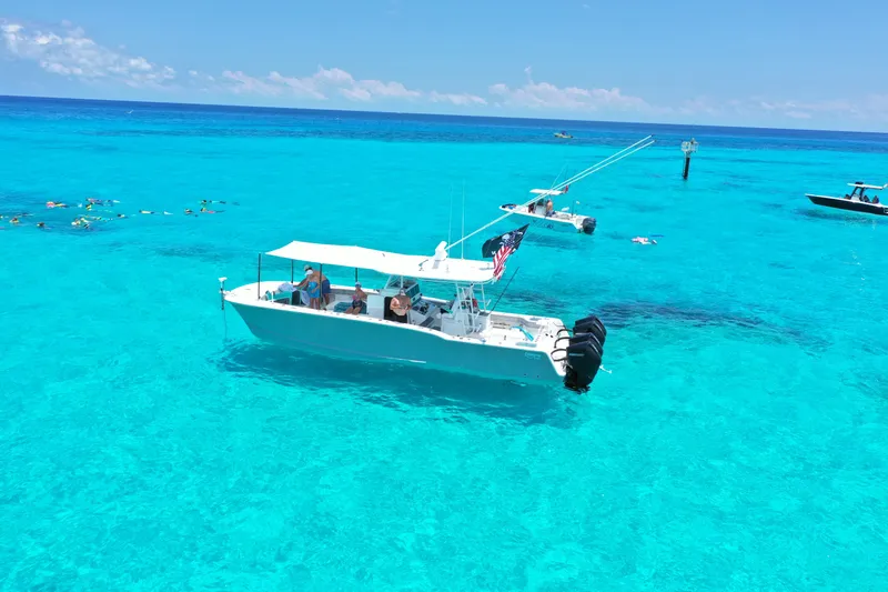  Yacht Photos Pics A Tideline 365 boat on clear turquoise water, surrounded by snorkelers, under a sunny sky.