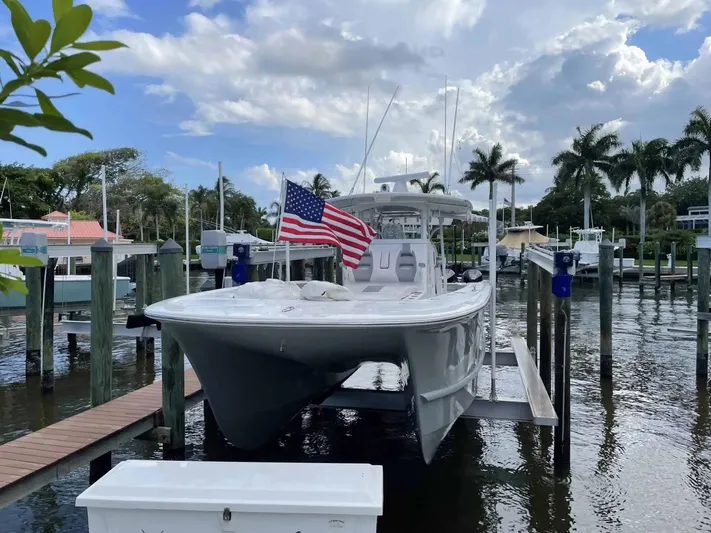  Yacht Photos Pics 2020 Tideline 365 boat docked with American flag, surrounded by palm trees and water.