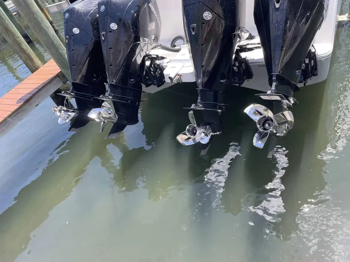  Yacht Photos Pics Four powerful outboard motors on a 2020 Tideline 365 boat, docked in calm water.